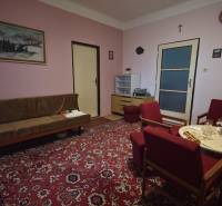 Living room in a family house with a red carpet and wooden furniture.