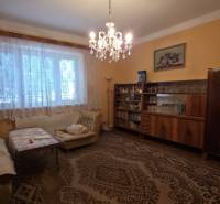 Living room in a family house with a chandelier and furniture, floor with a decorative carpet.