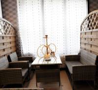 Rattan seating with a hookah, white curtains, and wooden panels in commercial spaces.