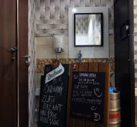 Interior commercial spaces with a mirror, sink, and boards with beverage offerings.