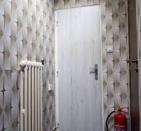 Commercial space with geometric wallpaper, doors, a radiator, and a fire extinguisher.
