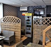 Commercial premises with rattan seating and a beverage refrigerator.