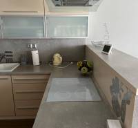 A kitchen unit in a 4-room apartment with an induction cooktop and a range hood.