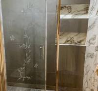 Shower enclosure with decorative glass and tiles in a 4-room apartment.