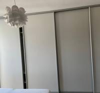 A built-in wardrobe with a light decor and an original ceiling chandelier in a 4-room apartment.
