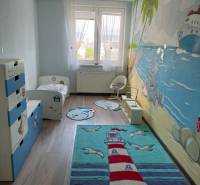 A children's room in a 4-room apartment with colorful carpets and a wall mural.