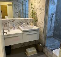 Luxury bathroom with a shower and marble tiles in a 4-room apartment.