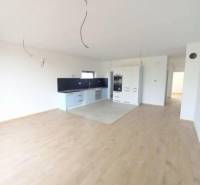 A kitchen with white cabinets, a dark countertop, and a wood-patterned floor.