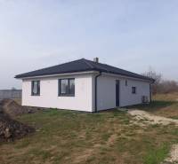 A family house in Galanta with a white facade stands on a grassy plot.