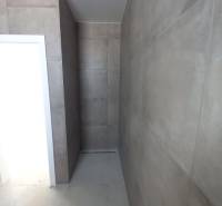 A bathroom in a family house with large-format tiles and a shower area without a tray.
