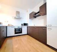 A kitchen with a wooden decor floor in a 2-room apartment.