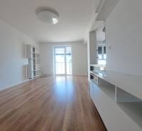 Living space in a 2-room apartment with a wooden decor floor and light-colored walls.