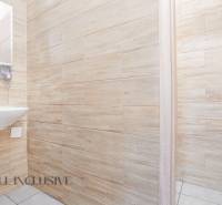 An office interior with a sink, wooden walls, and open doors.