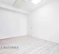 Interior with white walls and wood-patterned flooring in the office.