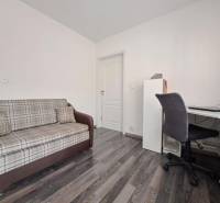 A sofa and a desk in a family house with a wooden decor floor.
