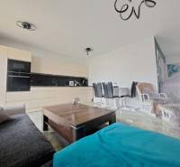 Living room in a family house with an open kitchen and dining table. Floor with wooden decor.