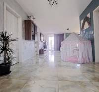 A hallway in a family house with shiny tiles and a children's tent.