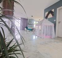 Interior of a family house with a tent for children on a shiny floor and plants.