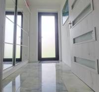 Interior of a family house with a glossy ceramic floor and glass doors.