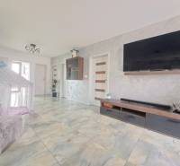 Living room in a family house with a TV on the wall, a tent, and ceramic flooring.