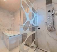 A bathroom with a modern shower, bathtub, and designer lighting in a family house.