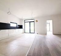 Spacious kitchen in a family house with a wooden decor floor and large windows.