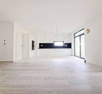 Spacious kitchen with black tiles and a wooden decor floor in a family house.