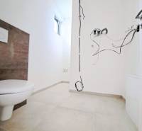 Bathroom in a family house with loose cables and a toilet, without accessories.