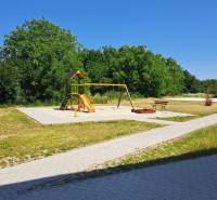 A playground with climbing frames and swings in Galanta surrounded by greenery and pathways.