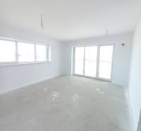 A spacious room in a 2-room apartment with light walls and large windows.