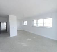 A spacious living area with large windows in a 2-room apartment.