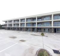 New building with balconies in Galanta for 2-room apartments, empty parking lot.