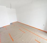 Unfinished commercial space with white walls and a floor covered with protective paper.