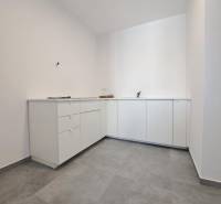 White cabinets in commercial spaces with gray tiles.