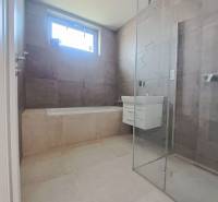 A bathroom in a family house with a bathtub, shower, and sink.