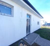Family house in Galanta, with a white facade and paving stones in the front garden.