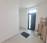 The entrance hall of the family house with tiles, next to the door is a step and material.