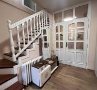 Hallway of a family house with wooden decor flooring and staircase.
