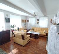 Living room of a family house with a wooden-patterned floor, a fireplace, and a comfortable sofa set.