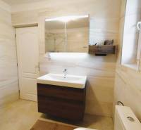A bathroom in a family house with white walls and a sink with a mirror.