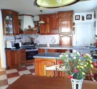 A kitchen in a family house with wooden cabinets and floral decorations.