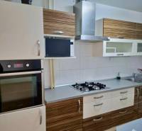 A kitchen with a stone sink, a cooktop, and an extractor hood in a 4-room apartment.