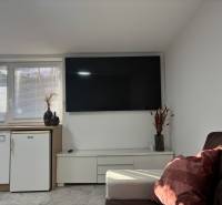 Living room in a family house with a television and a sofa, floor with wooden decor.