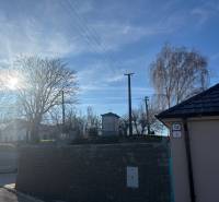 Sunny view of a family house in Blatné with a view of trees and power lines.