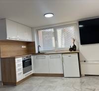 A kitchen in a family house with white cabinets and wood decor.