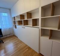 A study in a 3-room apartment with shelves and a wooden decor floor.