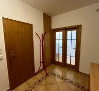Hallway of a 3-room apartment with tiles and wooden doors.