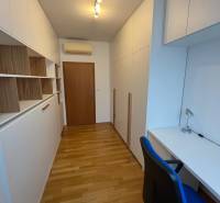 A study with white furniture, built-in wardrobes, and a wooden decor floor in a 3-room apartment.