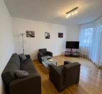Living room in a 3-room apartment with comfortable seating and a wooden decor floor.