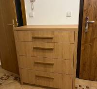 Hallway in a 3-room apartment with a cabinet and tiles.